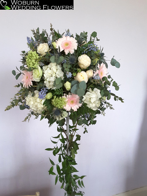 Tall table arragement including gerbera, hydrangea and roses.