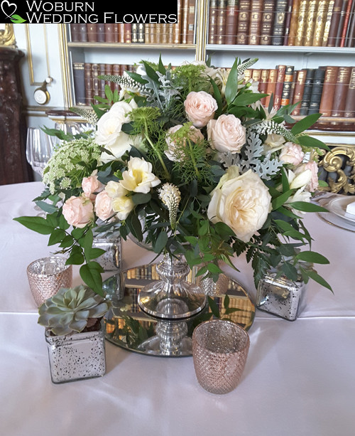 Urn arrangement with roses, freesia and veronica